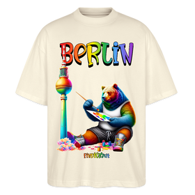 Illustration eines bunten Bären in Regenbogenfarben, der mit Pinsel und Farbpalette kreativ ist, vor dem Berliner Fernsehturm in Regenbogenoptik. Darüber der Schriftzug "Berlin" in Regenbogenfarben und darunter ganz klein "Findickjut". Perfekt zur Feier des CSD Berlin 2025. Oversized Unisex Bio T-Shirt -Naturweiß