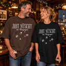 Lachendes Paar in einer weihnachtlich geschmückten Berliner Kneipe: Mann im braunen und Frau im schwarzen Oversize-Bio-T-Shirt mit weißem „JIBT NÜSCHT, ihr Flitzpiepen“-Weihnachtsmotiv und Geschenk-Illustrationen.