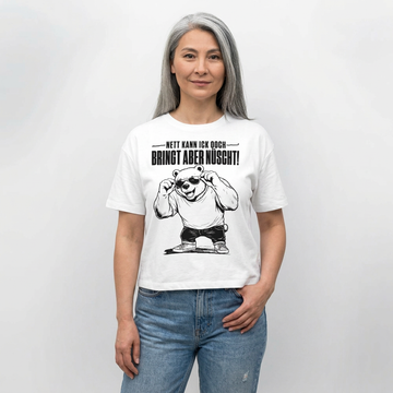Weißes Frauen Bio-T‑Shirt mit Berliner Bär und dem Spruch „Nett kann ick ooch – bringt aber nüscht“ auf der Vorderseite.