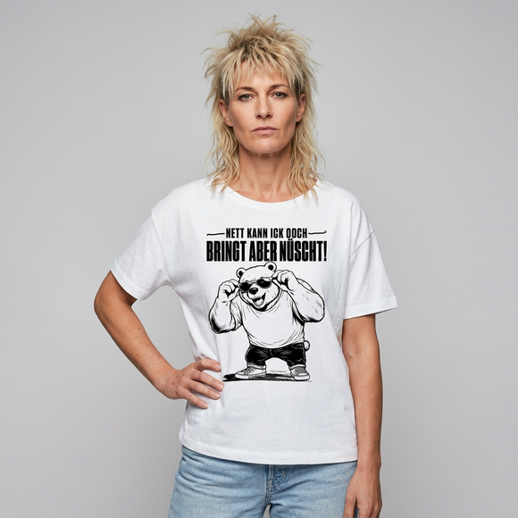 Weißes sommerlich leichtes Frauen Bio-T‑Shirt mit lockerem Rundhalsausschnitt und dem Berliner Bär mit Sonnenbrille sowie dem Spruch „Nett kann ick ooch – bringt aber nüscht" als Frontprint.