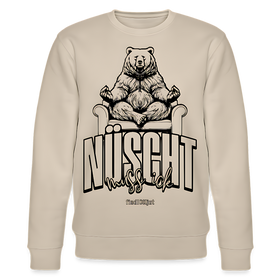 Beiger Unisex-Sweater mit großem schwarzem Print in Berliner Schnauze „NÜSCHT muss ick“ in markanter Schrift, darüber ein gezeichneter Bär in Meditationspose auf einem Sessel. Der Sweater hat Rundhalsausschnitt, eingesetzte Ärmel und gerippte Bündchen aus 100% Bio-Baumwolle, Stoffdichte 350 g/m².