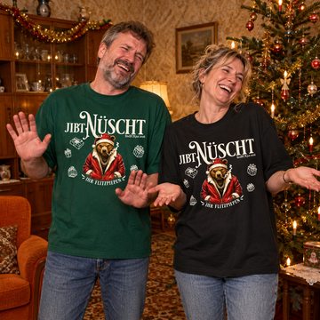 Mann und Frau lachen in einem weihnachtlich geschmückten 90er-Jahre-Wohnzimmer. Sie tragen das Relaxed-Fit-Shirt „Jibt Nüscht – Ihr Flitzpiepen“ mit Weihnachtsbär in Grün und Schwarz.