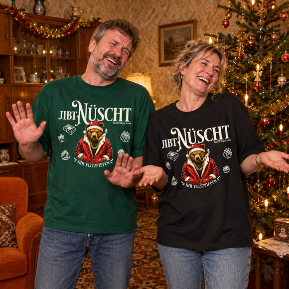 Mann und Frau lachen in einem weihnachtlich geschmückten 90er-Jahre-Wohnzimmer. Sie tragen das Relaxed-Fit-Shirt „Jibt Nüscht – Ihr Flitzpiepen“ mit Weihnachtsbär in Grün und Schwarz.